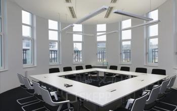 Modern conference room available for office space rental at Fleischmarkt 1, in 1010 Vienna Center with a large table and ergonomic chairs.